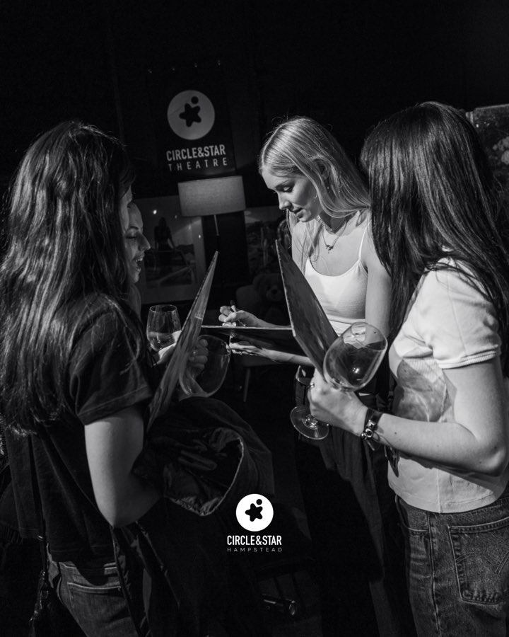 The artist signing records for audience members after the show