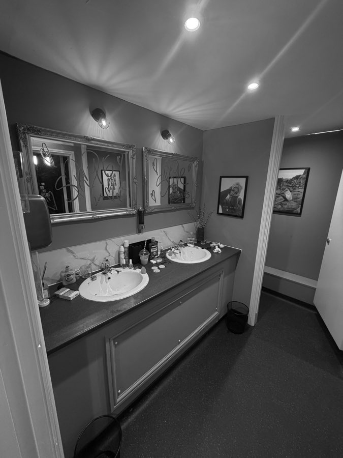 The theatre bathrooms, mirrors written on, framed images on the wall